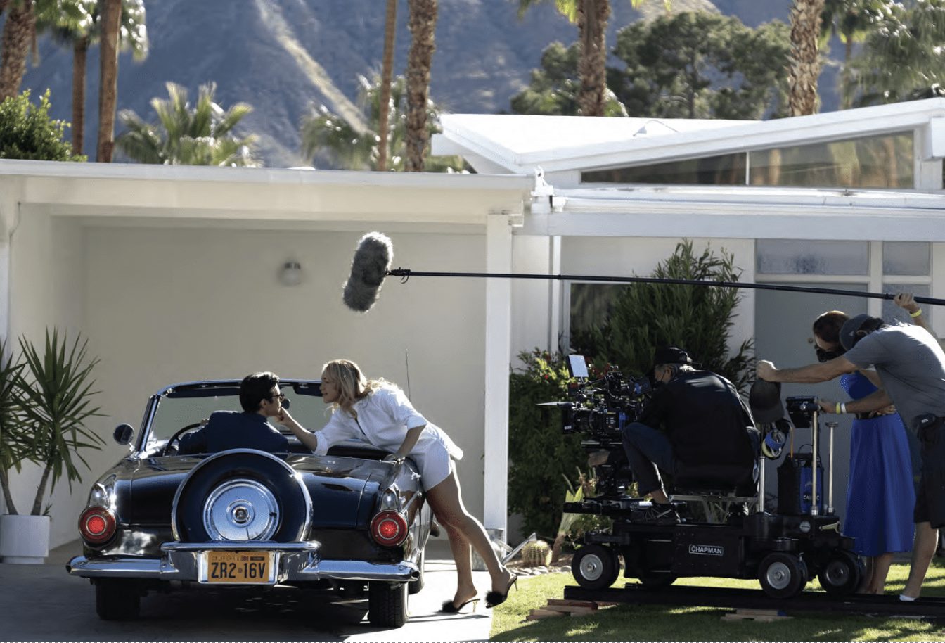 Harry Styles, left, and Florence Pugh on the set of “Don’t Worry Darling” with Olivia Wilde (blue dress) directing. PHOTO: WARNER BROS.