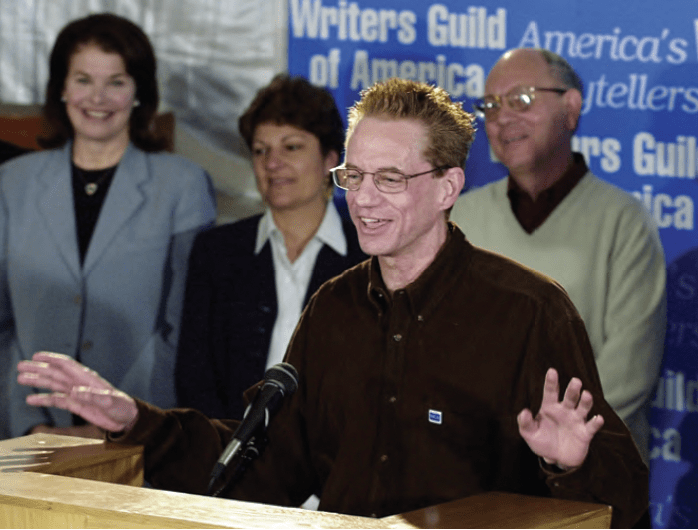 Michael Mahern, co-chair of the negotiating committee for the Writers Guild of America, gestures during a news conference to announce an agreement with producers averting a strike, Friday, May 4, 2001, in Los Angeles. In the background, from left, is Paramount Pictures-Motion Picture Group Chairman and CEO, Sherry Lansing, Carol Lombardini, Sr. Vice President of the Alliance of Motion Picture and Television Producers and guild consultant, Bob Hadl. PHOTO: COURTESY AP